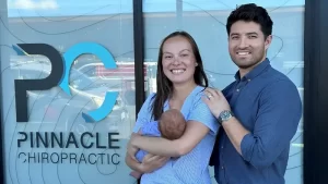Family photo outside of Pinnacle Chiropractic celebrating the clinic being open for 1 year.